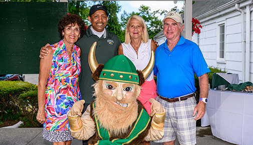 Golf Classic participants pose with Viking mascot