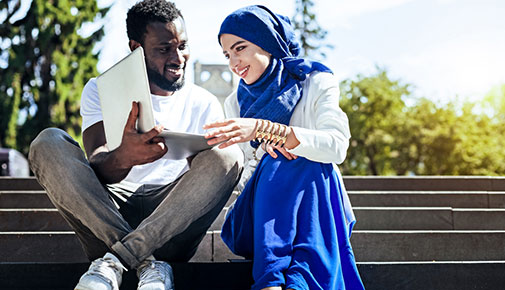 Two international students studying on steps outside