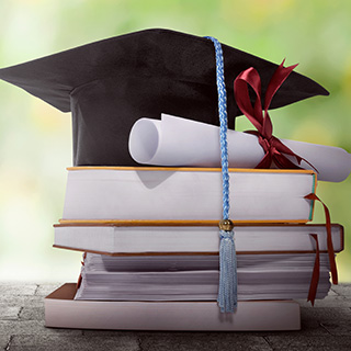 Graduation cap sitting on top of a pile of books