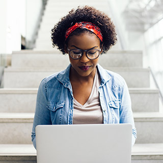 Student working on laptop in a stairwell