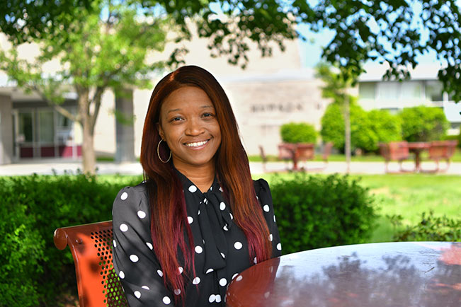 Akedra W. sitting outside on campus