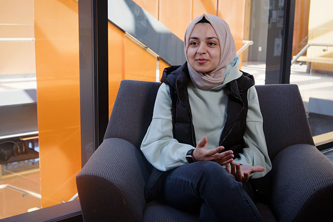 Mariam in a chair on campus