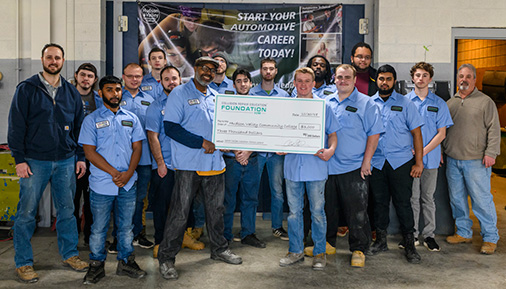 Autobody students and instructor pose with donation check