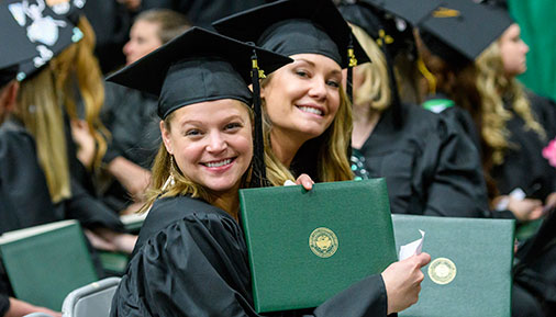 Smiling graduates at commencement