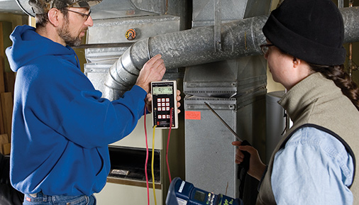Two students testing the efficiency of a heating system