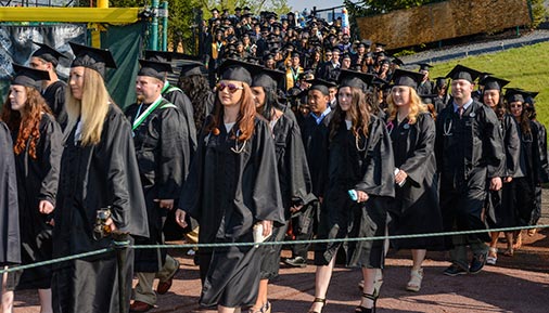 Large group of graduates walking into stadium