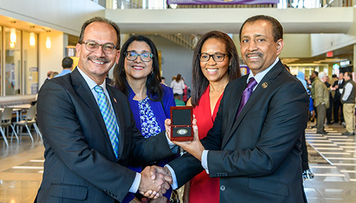 UAlbany President Rodríguez and HVCC President Ramsammy shake hands with their wives' looking on in the background