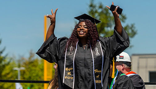 Graduate smiling and crossing the stage
