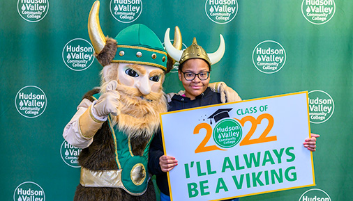 Graduate poses with Viking mascot and class of 2022 sign