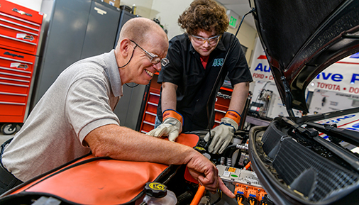 Dr. Chris McNally works with a student on an electric vehicle.